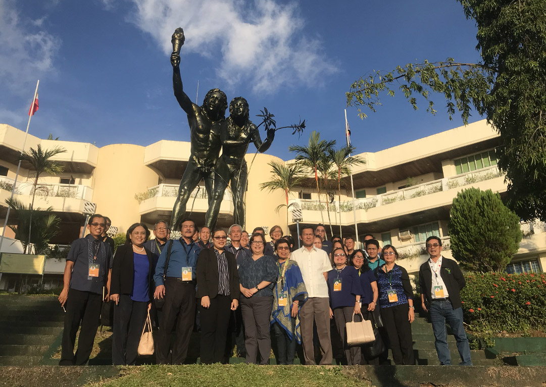 Auditors from TUV Rheinland pose with VSU administrators in front of the Search for Truth statue.